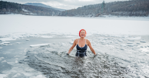 A woman cold plunging in a mountain lake.